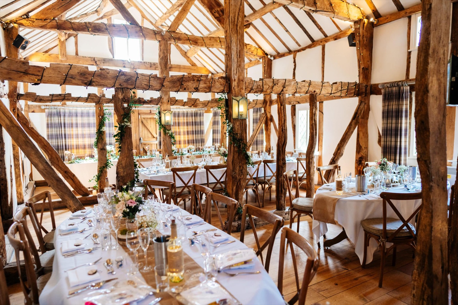 Tables laid for a celebration in the oak barn at The Plough